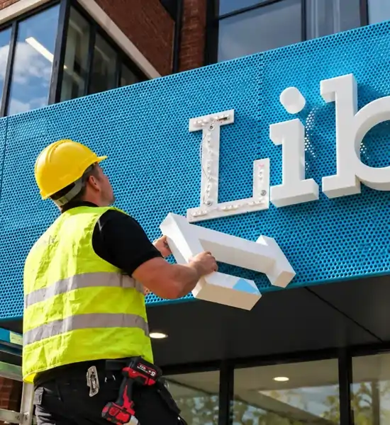 Técnico realizando mantenimiento y reparación de letreros en Lima